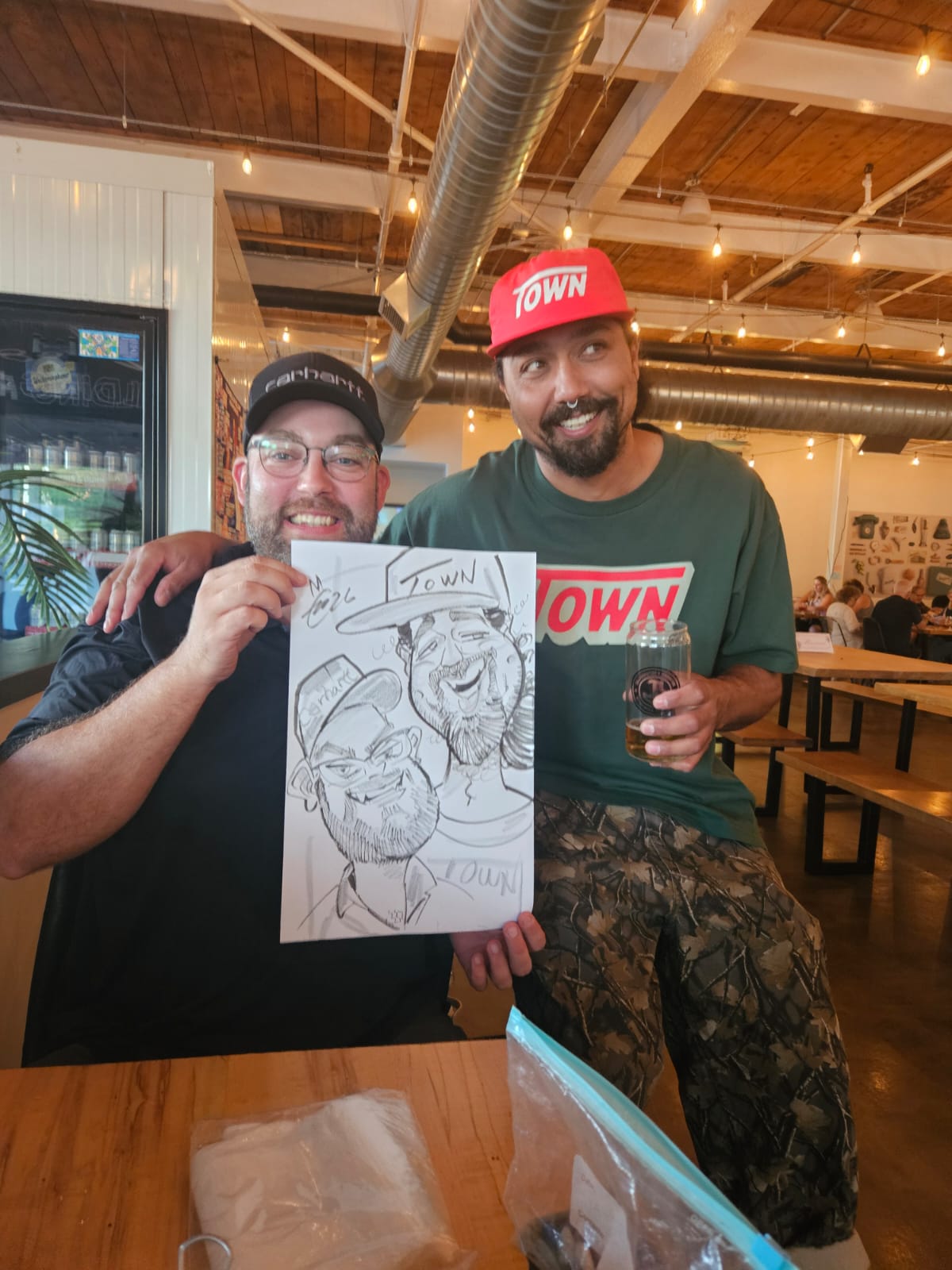 Two friends holding a live duo caricature by Cathy