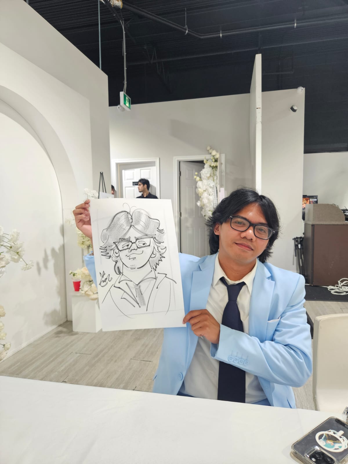Guest holding a charcoal caricature drawn live at an event
