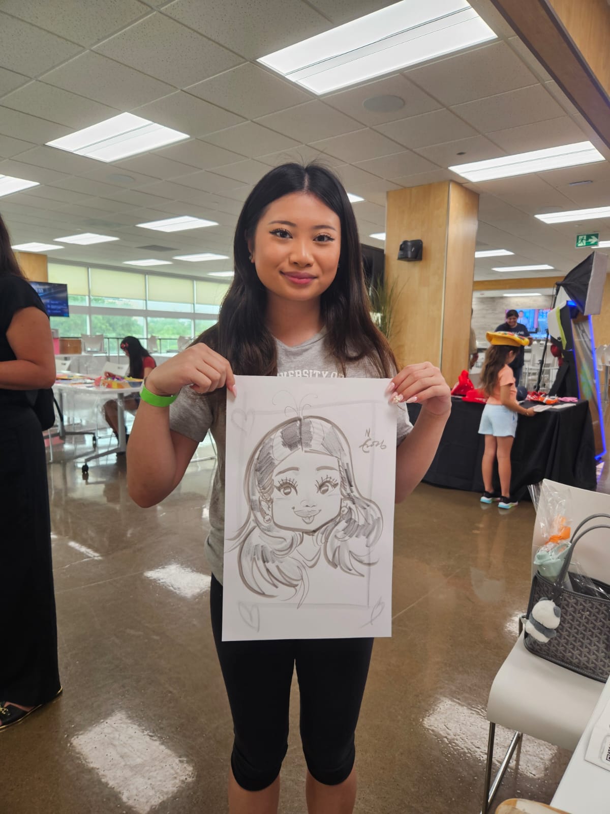 Student smiling with her live caricature drawn by Cathy