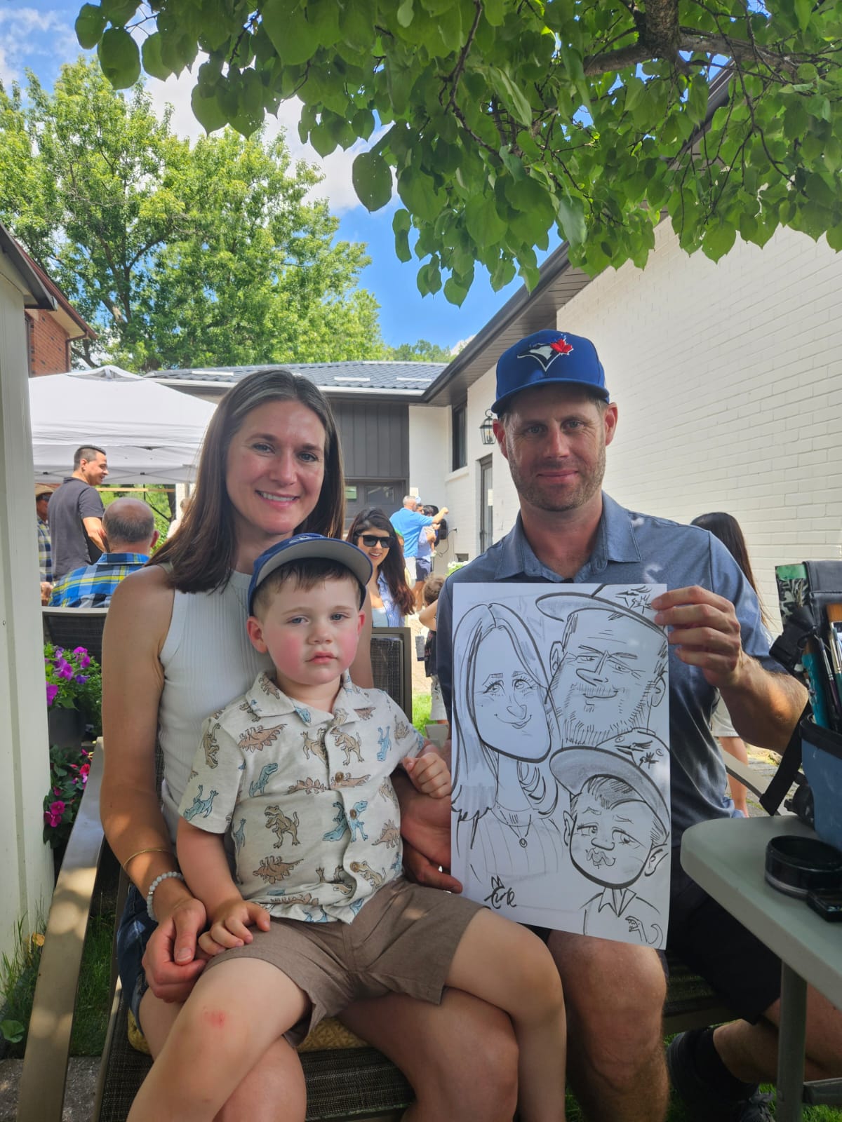 Family holding their live black and white caricature by Cathy