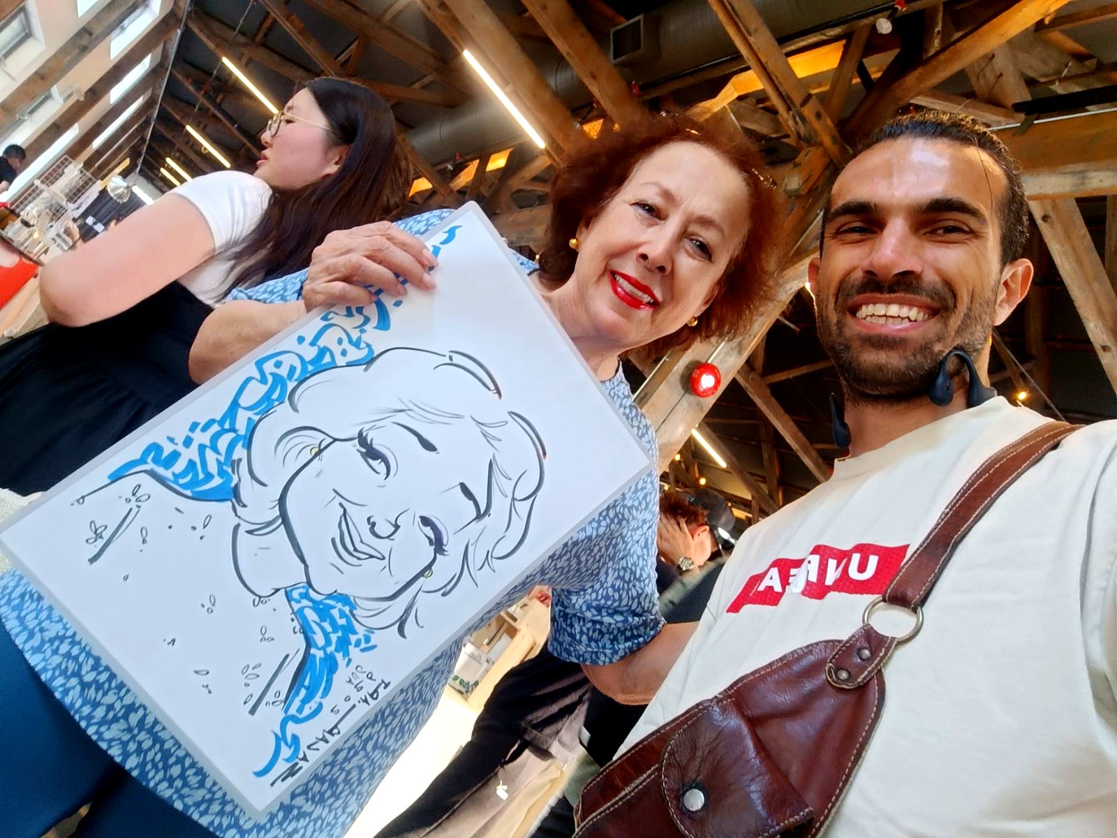 Guest with her blue-accent live caricature — Granville Island, Vancouver